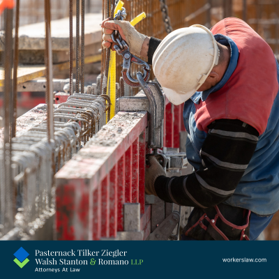 A Brooklyn construction worker guides a heavy item to the ground with a crane