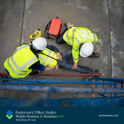 Two workers attend to another on the ground after a workplace accident